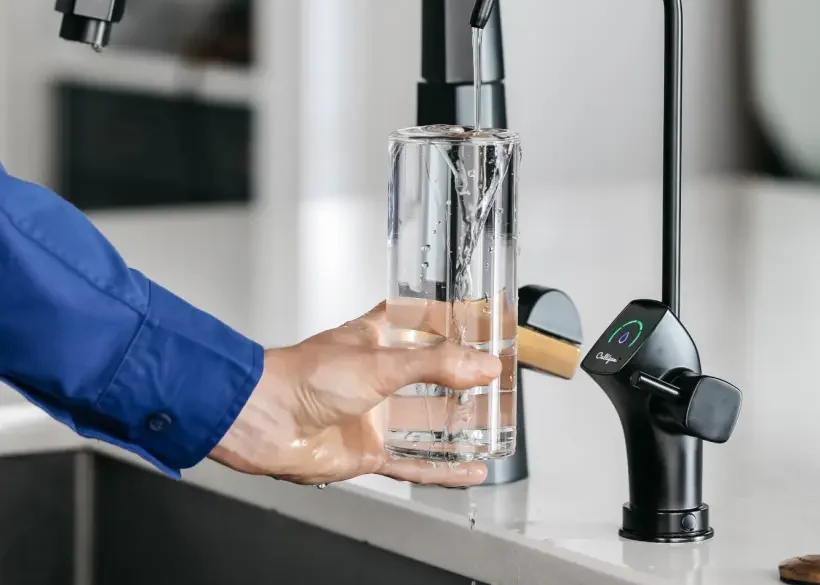 Filling a glass from a Culligan drinking-water faucet at home